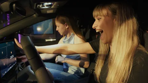 Due ragazze provano l’auto durante la festa